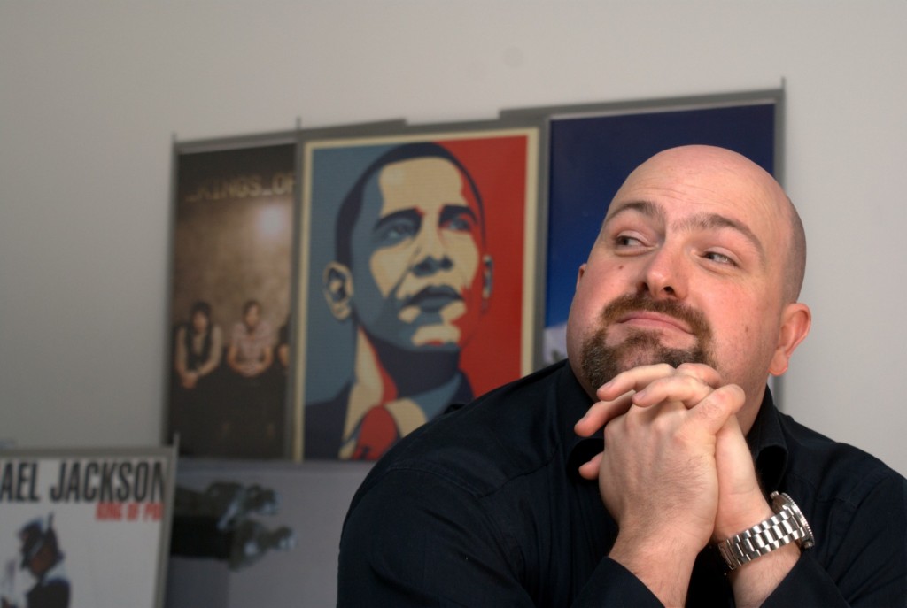 NHS Views editorial photograph Man looking over his shoulder at a poster of Barack Obama