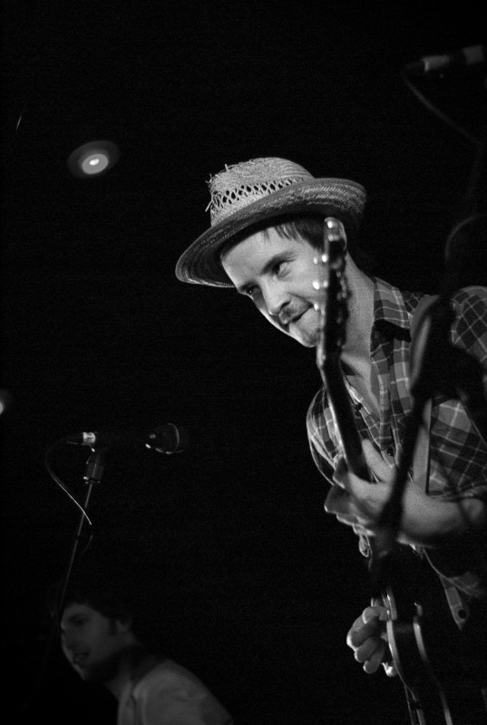 The Holloways gig photographer Man smiling at the crowd while he plays a guitar