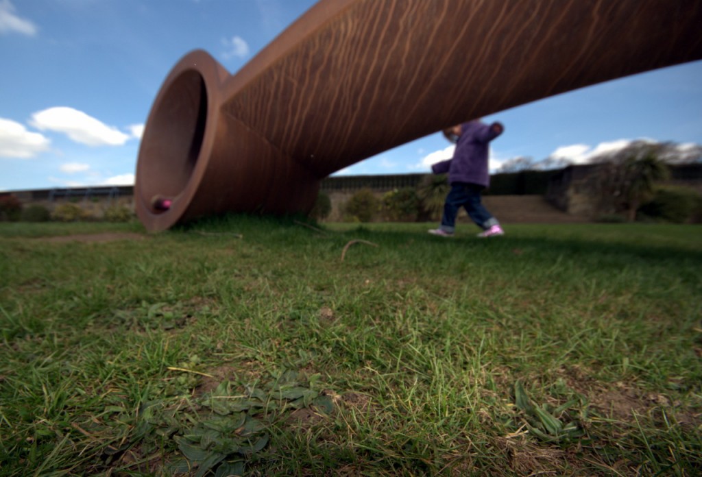 Yorkshire sculpture park editorial photography Child playing on some grass behind a sculpture at Yorkshire sculpture park