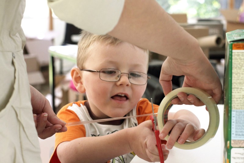 Art as environment children's art event at Yorkshire Sculpture Park Boy cutting Sellotape at Yorkshire Sculpture Park