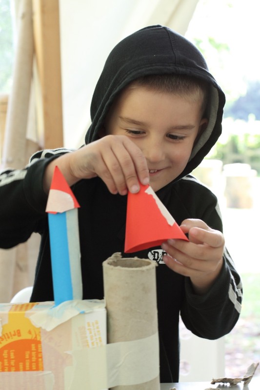 Art as environment children's art event at Yorkshire Sculpture Park Boy arranging paper sculptures at Yorkshire Sculpture Park