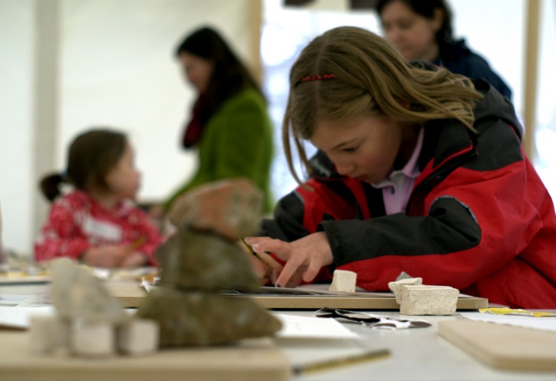 Children's sculpture art event at Yorkshire Sculpture Park Girl drawing behind some stones at Yorkshire Sculpture Park