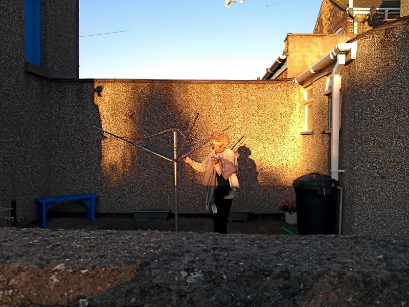 Backyard sunset An old woman hangs out her washing in a sunlit backyard in Grimsby