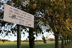 Public sign in a park in Chapel Allerton, Leeds. It reads "The riding of motor cycles and horses or the playing of golf strokes is strictly prohibited on this land"