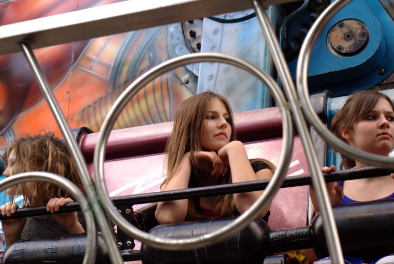 Fairground A young girl on a fairground ride shot through some railings