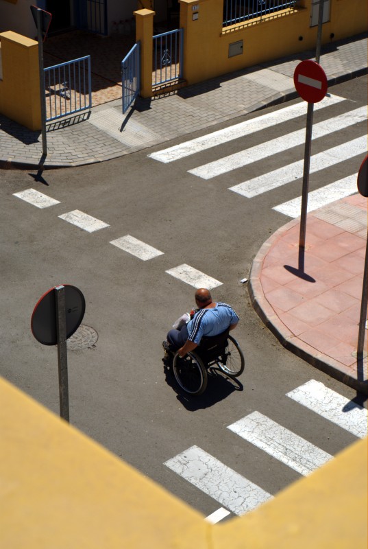 Wheelchair junction A man in a wheelchair crossing a road junction