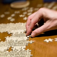 Hand placing a jigsaw piece into a puzzle