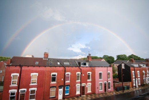 Two rainbows in a dark sky over terraced houses in Leeds