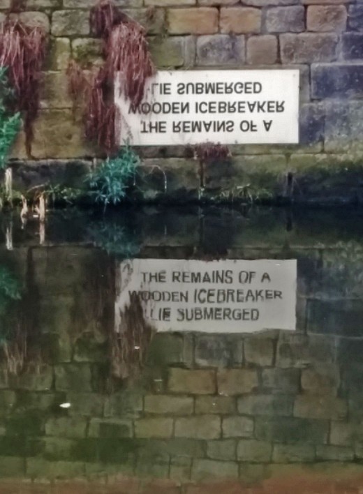 Notice by Leeds Liverpool Canal that reads "The remains of a wooden icebreaker lie submerged"